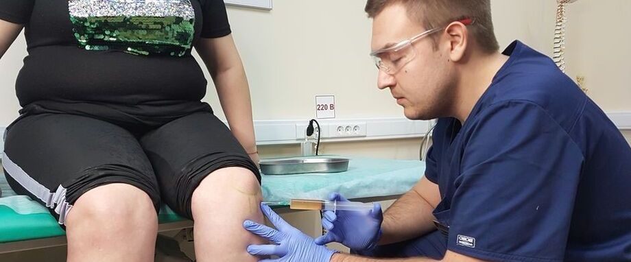 Gydytojas ortopedas atlieka intraartikulinę injekciją į kelio sąnarį dėl osteoartrito